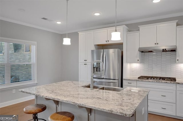 541 Glen Abbey Cir, Mableton, GA 30126 - kitchen featuring appliances with stainless steel finishes, under cabinet range hood, wood finished floors, decorative backsplash, and a breakfast bar