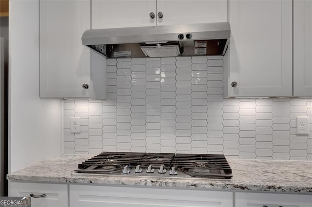 541 Glen Abbey Cir, Mableton, GA 30126 - kitchen with under cabinet range hood, stainless steel gas stovetop, decorative backsplash, and white cabinetry