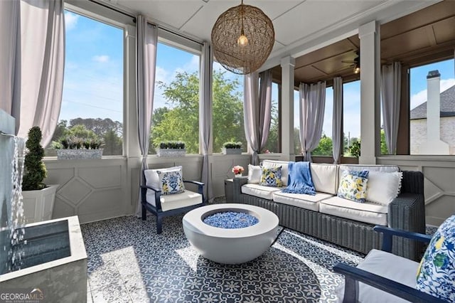 sunroom / solarium featuring an outdoor living space with a fire pit and a ceiling fan