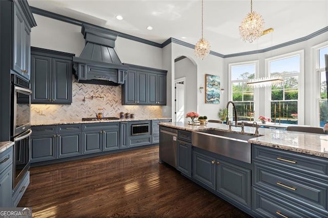 kitchen featuring a sink, appliances with stainless steel finishes, arched walkways, crown molding, and dark wood-style floors