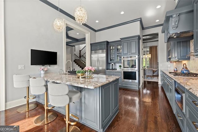 kitchen featuring stainless steel appliances, ornamental molding, dark wood finished floors, glass insert cabinets, and gray cabinetry