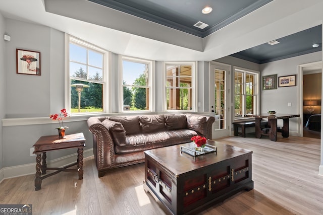living area with ornamental molding, wood finished floors, a raised ceiling, baseboards, and recessed lighting