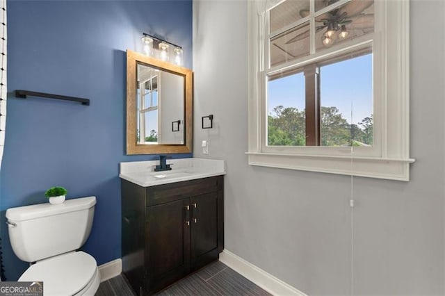 bathroom featuring baseboards, toilet, and vanity