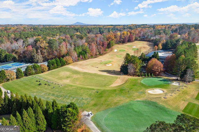 aerial view of property's location with a heavily wooded area and a golf course