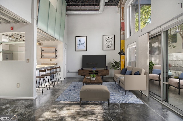 195 Arizona Ave Unit 179, Atlanta, GA 30307 - living room featuring a towering ceiling, concrete floors, and baseboards