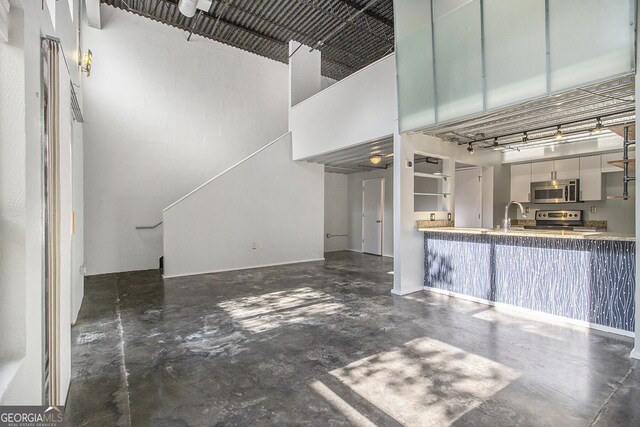 195 Arizona Ave Unit 179, Atlanta, GA 30307 - kitchen with stainless steel appliances, concrete flooring, a towering ceiling, and a sink