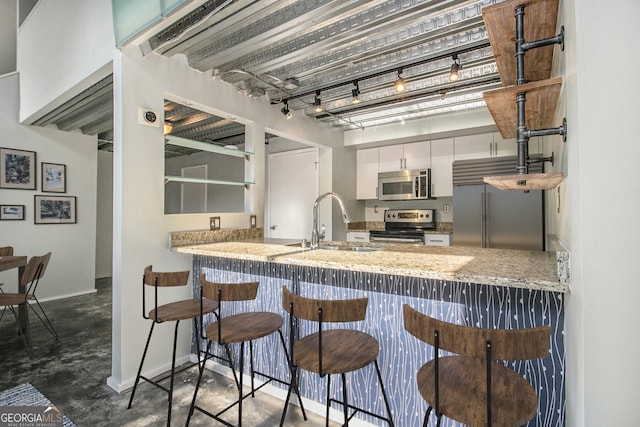 195 Arizona Ave Unit 179, Atlanta, GA 30307 - kitchen featuring appliances with stainless steel finishes, concrete floors, a peninsula, and baseboards