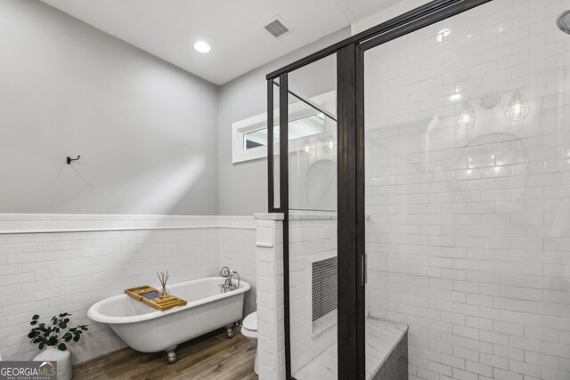 1211 Mortimer Pl SE, Atlanta, GA 30317 - full bath with wood finished floors, a stall shower, a freestanding bath, wainscoting, and tile walls