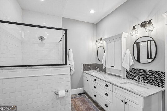 1211 Mortimer Pl SE, Atlanta, GA 30317 - bathroom featuring a tile shower, double vanity, backsplash, recessed lighting, and baseboards