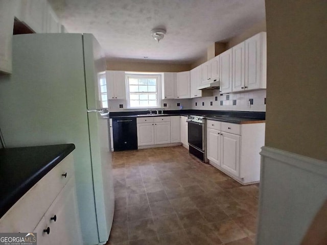 3026 Hidden Forest Dr, Snellville, GA 30078 - kitchen featuring black dishwasher, freestanding refrigerator, gas range oven, dark countertops, and under cabinet range hood