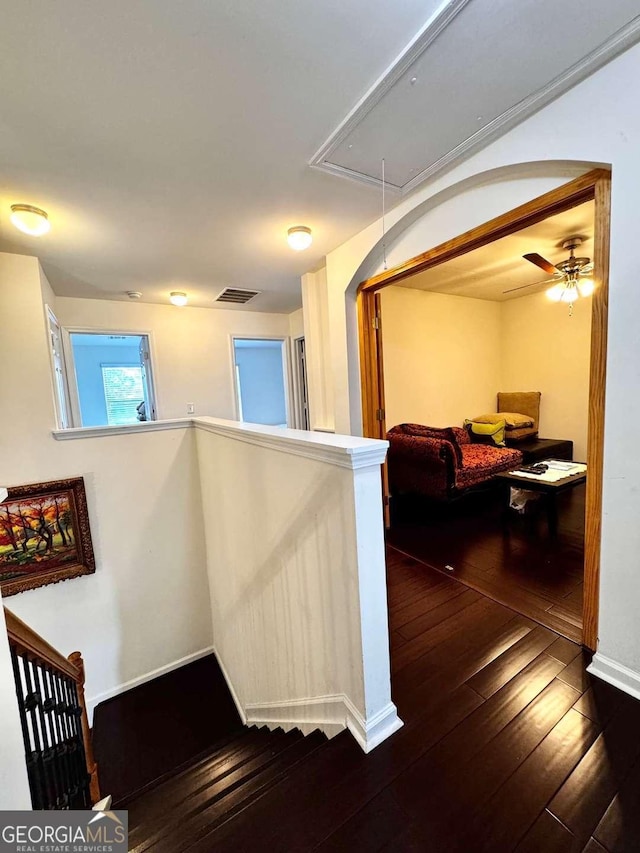 stairway with attic access, hardwood / wood-style floors, and baseboards