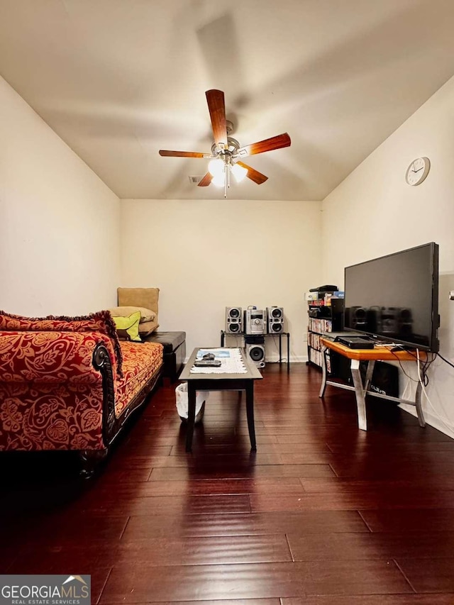 living area with a ceiling fan, hardwood / wood-style flooring, and baseboards