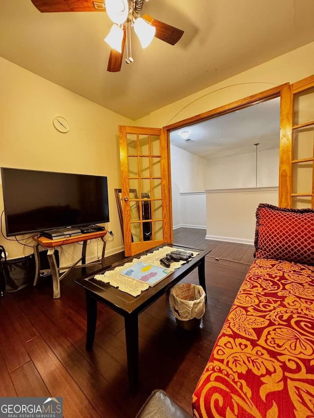 living room with hardwood / wood-style floors, baseboards, a ceiling fan, and lofted ceiling