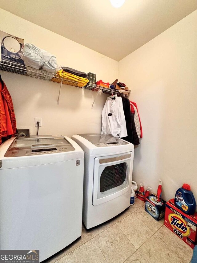 laundry room featuring washer and dryer and light tile patterned floors