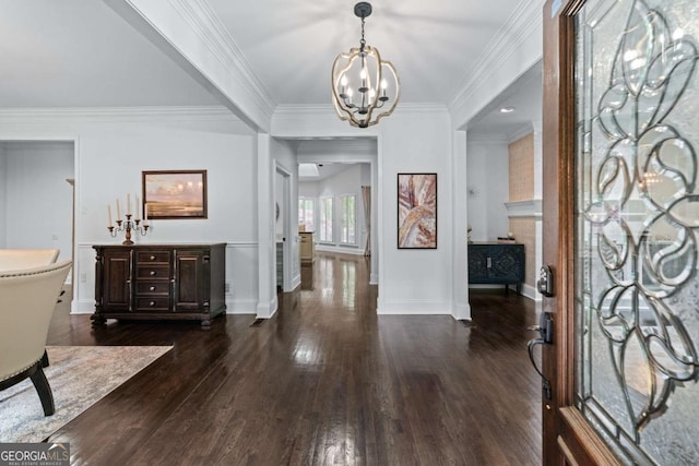 foyer featuring a chandelier, dark wood finished floors, ornamental molding, and baseboards
