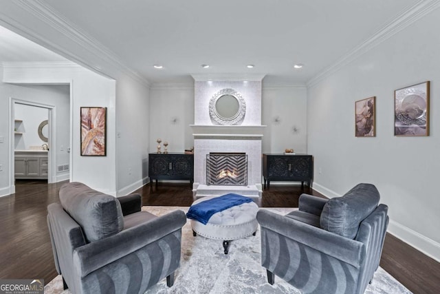 living room featuring baseboards, wood finished floors, a large fireplace, ornamental molding, and recessed lighting