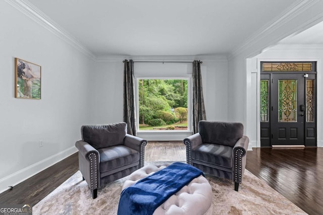 sitting room with ornamental molding, wood finished floors, and baseboards