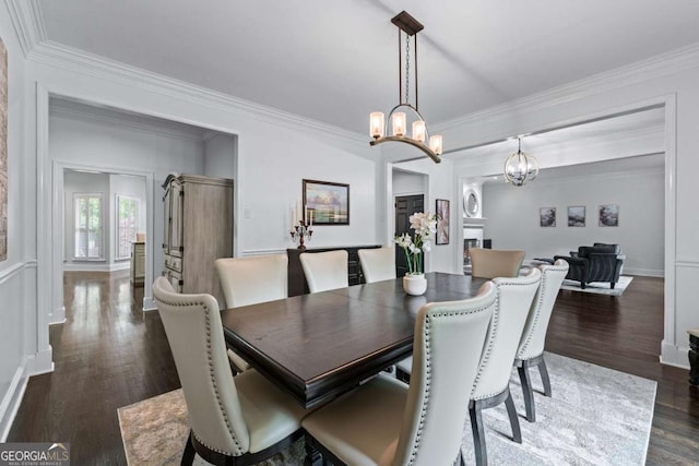 dining space with dark wood-style floors, ornamental molding, a chandelier, and baseboards