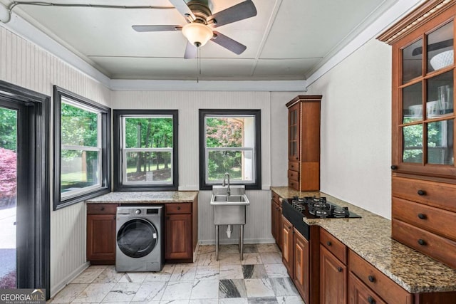 laundry area featuring washer / dryer, crown molding, ceiling fan, baseboards, and a sink