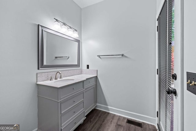 bathroom featuring vanity, wood finished floors, and baseboards