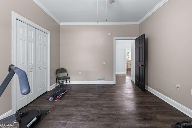 unfurnished bedroom featuring ornamental molding, dark wood finished floors, a closet, baseboards, and ceiling fan