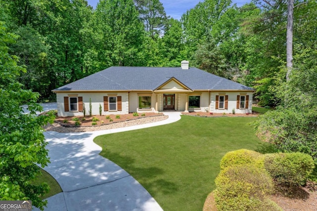 view of front of home with a front yard, a chimney, and roof with shingles