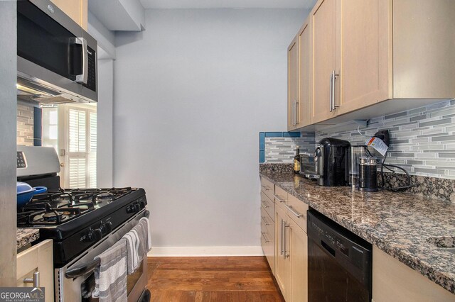 61 16th St NE Unit 4, Atlanta, GA 30309 - kitchen with appliances with stainless steel finishes, dark wood-style flooring, backsplash, and dark stone counters