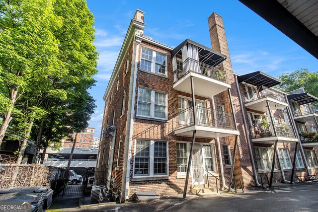 61 16th St NE Unit 4, Atlanta, GA 30309 - back of house featuring brick siding, entry steps, and a chimney