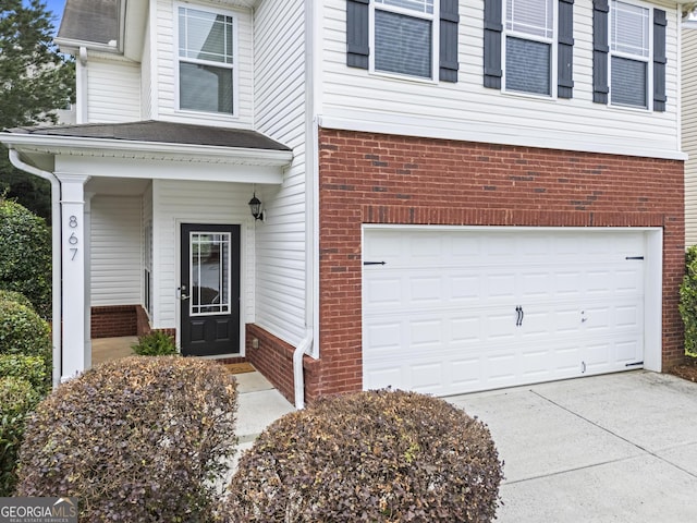 867 Crested Hawk Trl, Sugar Hill, GA 30518 - entrance to property featuring brick siding, an attached garage, and concrete driveway