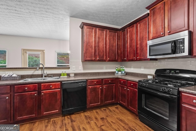 867 Crested Hawk Trl, Sugar Hill, GA 30518 - kitchen featuring black appliances, reddish brown cabinets, dark wood-style floors, and a textured ceiling