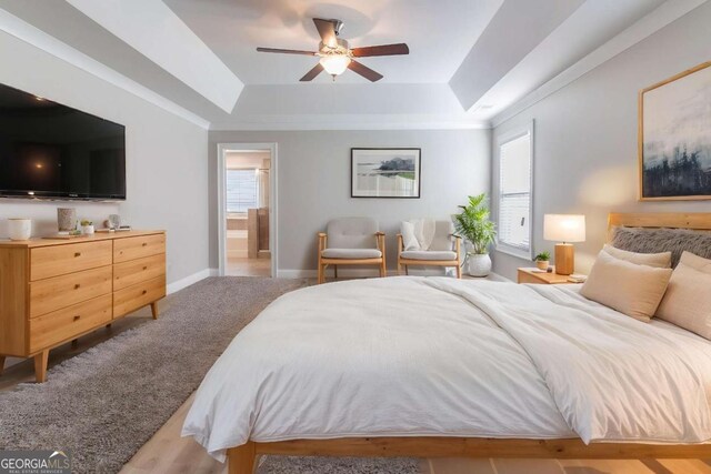 4183 May Apple Ln, Atlanta, GA 30349 - bedroom with a raised ceiling, baseboards, connected bathroom, and ceiling fan
