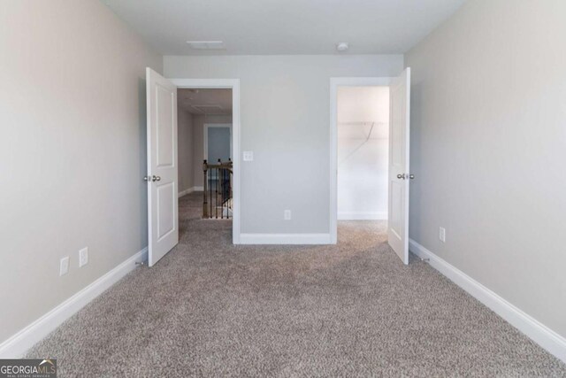 4183 May Apple Ln, Atlanta, GA 30349 - unfurnished bedroom featuring carpet floors, a walk in closet, and baseboards