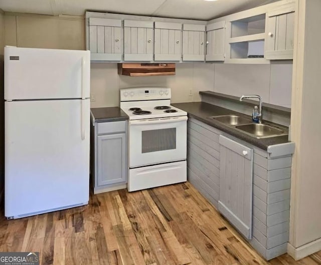 916 Friendly Mission Ln, Cornelia, GA 30531 - kitchen with white appliances, a sink, dark countertops, under cabinet range hood, and light wood finished floors