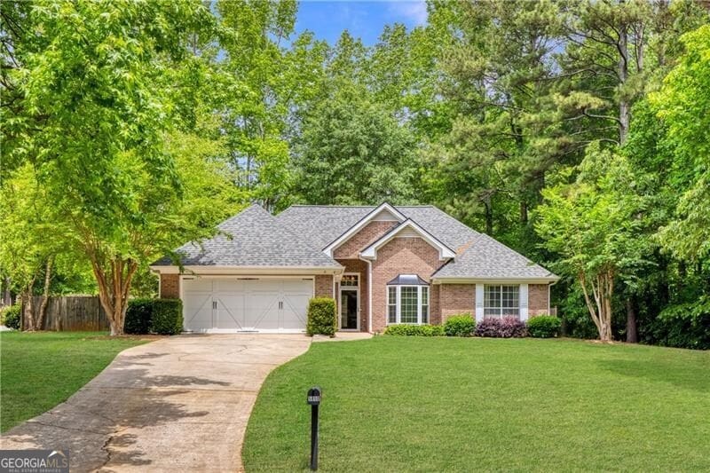 5850 Shannon Dr, Cumming, GA 30040 - view of front facade featuring a garage, driveway, brick siding, and roof with shingles