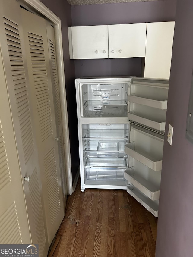 detailed view of wood finished floors and white cabinets