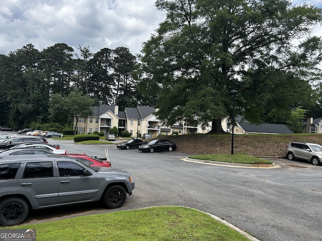 view of asphalt street with curbs, street lights, and a residential view