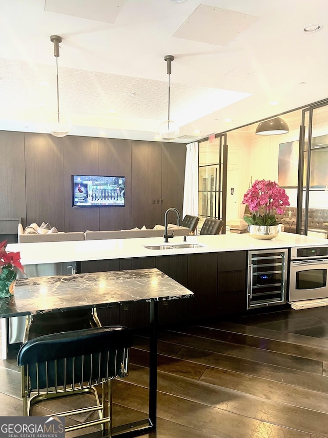 325 E Paces Ferry Rd NE Unit 1606, Atlanta, GA 30305 - bar featuring oven, wine cooler, a sink, dark wood-style flooring, and hanging light fixtures