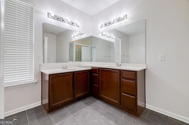 full bathroom featuring tile patterned floors, double vanity, and baseboards