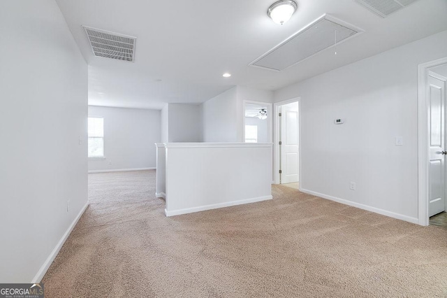 unfurnished room with attic access, light colored carpet, baseboards, and recessed lighting