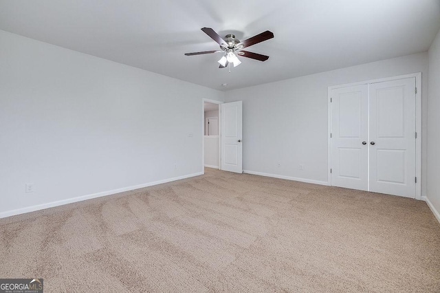 unfurnished bedroom featuring carpet, baseboards, a closet, and ceiling fan