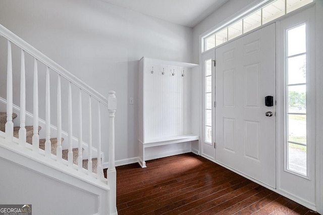 foyer featuring dark wood-type flooring and stairs