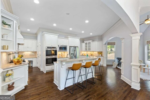 3302 Anna Ruby Ln, Buford, GA 30519 - kitchen featuring open shelves, appliances with stainless steel finishes, ornamental molding, arched walkways, and white cabinets