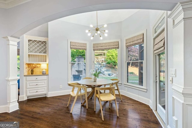 3302 Anna Ruby Ln, Buford, GA 30519 - dining area with dark wood-type flooring, a chandelier, decorative columns, baseboards, and arched walkways