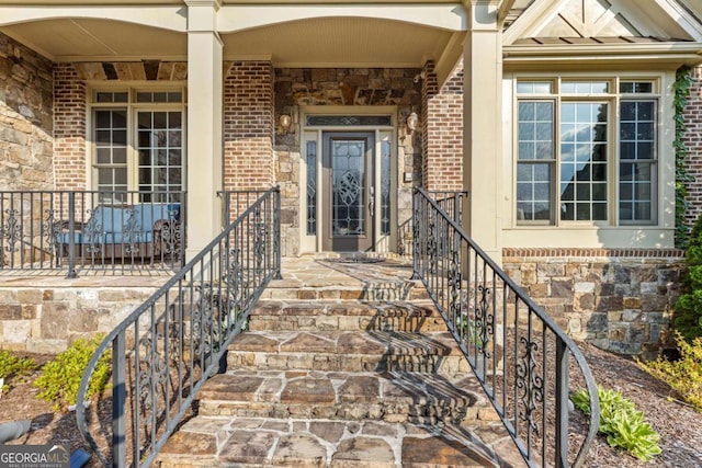 3302 Anna Ruby Ln, Buford, GA 30519 - doorway to property with brick siding, stone siding, a standing seam roof, and a porch