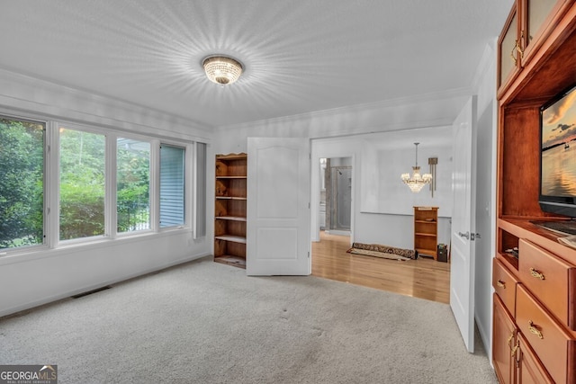 unfurnished bedroom featuring a chandelier, light carpet, baseboards, and ornamental molding