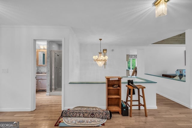 kitchen with wood finished floors, a chandelier, and baseboards
