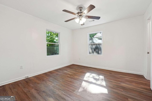 empty room featuring plenty of natural light, wood finished floors, and ceiling fan