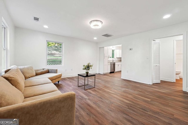 living area featuring wood finished floors, baseboards, and recessed lighting