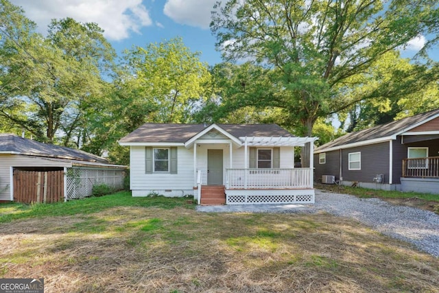 view of front facade featuring crawl space, a pergola, an outdoor structure, central AC unit, and fence