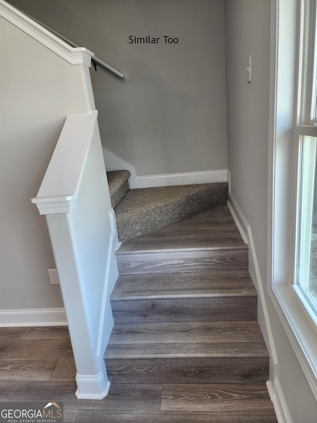 stairway with wood finished floors and baseboards